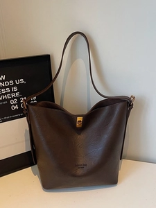 Minimalist dark brown bucket bag with lychee texture and gold buckle for daily commuting