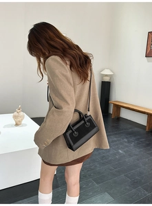 Detail of black patchwork leather handbag showing smooth and suede texture contrast