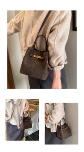 Detail of dark brown suede bucket bag featuring golden buckle and versatile straps