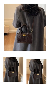 Detail of dark brown crocodile pattern crossbody bag styled with a grey winter coat