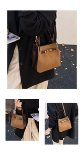Detail of vintage brown suede bucket bag with gold metallic buckle and handle