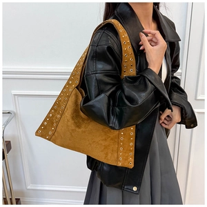 Detail of brown suede hobo bag with metallic grommets on shoulder strap and edges