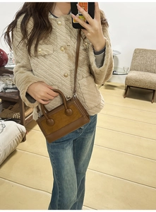 Mirror selfie showing a brown vintage leather handbag with textured patchwork and handle
