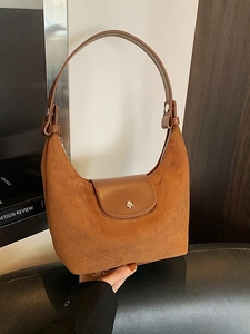 Borsa hobo in pelle e camoscio marrone con fibbia in metallo in uno scatto lifestyle autunnale