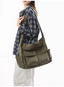 Olive green canvas utility shoulder bag with multiple pockets and adjustable strap