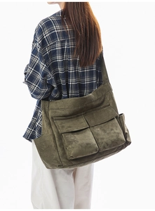 Detail of vintage canvas messenger bag in olive green with functional front pockets