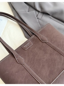 Détail du sac cabas marron foncé avec surpiqûres blanches et étiquette Fashion M.G