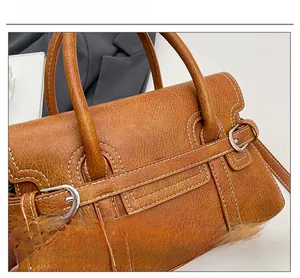 Close-up of brown vintage leather handbag showing silver buckle and detailed stitching