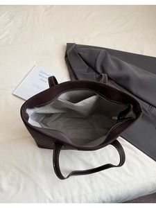 Détail intérieur d'un sac cabas marron avec doublure grise et poche zippée