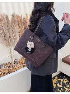 Détail du grand sac cabas marron foncé avec surpiqûres et charmant pendentif chien