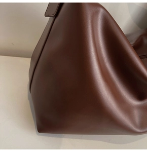 Close-up detail of soft caramel leather texture on the minimalist vintage tote bag
