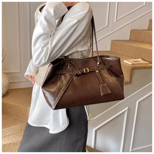 Détail d'un grand sac cabas en cuir marron foncé avec surpiqûres blanches contrastées