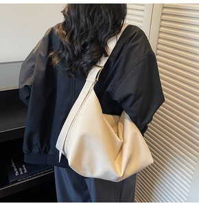 Macro detail of creamy white matte leather hobo bag with adjustable gold metal buckle