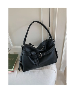 Close-up of black pebble grain leather tote with silver buckle and zipper details