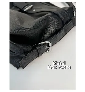 Close-up of silver hardware buckle and litchi grain black leather on tote bag