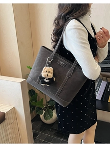 Détail du sac cabas en daim gris anthracite avec surpiqûres et breloque petit chien