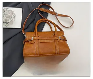 Detailed view of caramel brown vintage crossbody bag with metal buckle and size scale