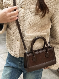 Deep brown retro crossbody bag with leather and suede panels and unique round handle base