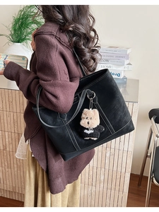 Détail du grand sac cabas noir en cuir avec coutures blanches et breloque ours en peluche