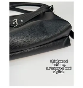 Detail of the thickened base on a black pebble leather tote bag with a structured shape
