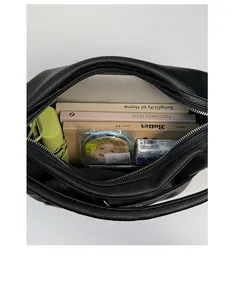 Interior view of large black leather tote bag showing spacious capacity with everyday items