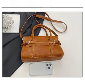 Brown vintage handbag capacity view showing white stitching and space for a smartphone