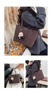 Détail d'un grand sac cabas vintage marron avec surpiqûres et pendentif ours en peluche