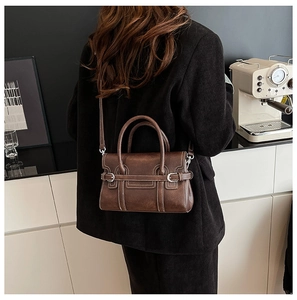 Brown leather crossbody bag with white contrast stitching and silver hardware detail