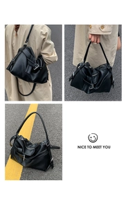 Detail view of large black lychee leather tote bag with knot strap and silver hardware