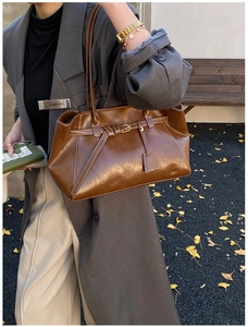 Détail d'un sac cabas marron foncé en cuir huilé vintage avec boucle et pendentif