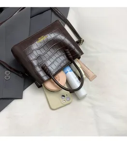Détail du sac seau marron foncé à motif croco montrant l'intérieur spacieux et doré
