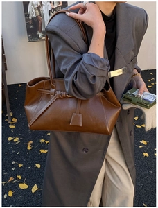 Gros plan sur un sac cabas marron vintage avec laçage élégant et surpiqûres blanches