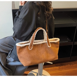 Close-up of brown suede tote bag with white faux fur trim and visible stitching detail