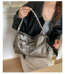 Detail of silver boston bag featuring lychee texture leather and decorative buckle strap