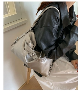 Detailed side view of silver metallic leather tote bag with buckle strap on model