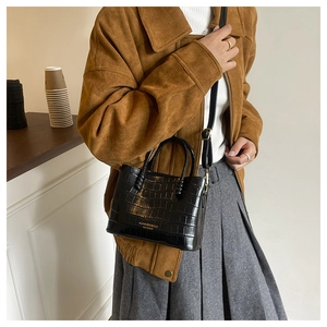 Détail du sac à main noir motif crocodile avec lettrage doré et bandoulière réglable