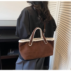 Detail of dark brown suede tote with faux shearling trim and adjustable shoulder strap