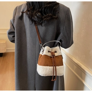 Detail of plush winter bucket bag showing suede texture and faux shearling trim
