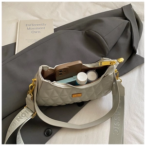Detail of quilted shoulder bag with golden hardware showing spacious interior compartment
