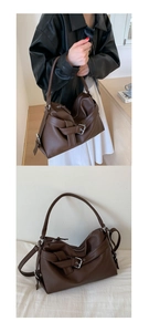 Detail of dark brown lychee grain leather tote with retro buckle and soft pleated texture