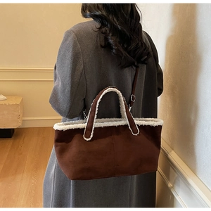 Détail du sac cabas en daim marron avec bordure en fausse fourrure blanche et sangle
