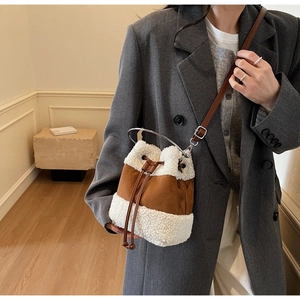 Detail of plush bucket bag with lamb wool and suede texture on gray suit outfit
