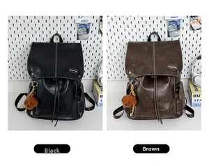 Detail showing two vintage faux leather backpacks in black and brown with plush charms