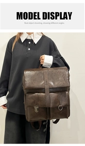Detail view of a vintage dark brown leather backpack with metal buckles and two pockets