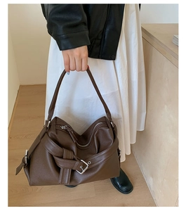 Close-up of vintage brown tote bag featuring lychee texture and silver buckle detail