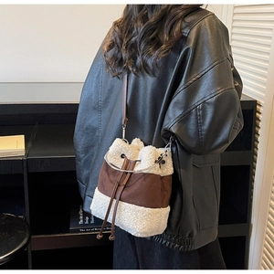 Detail of plush cream faux fur and brown suede bucket bag with drawstrings