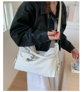 White lychee texture tote bag with leather buckle detail worn by a model in black