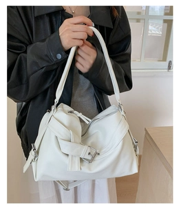 Detail of cream white pebbled leather tote bag with stylish belt buckle on the shoulder