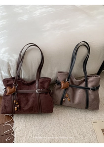 Close-up of retro suede tote bags with heart pendant and beaded tassel details