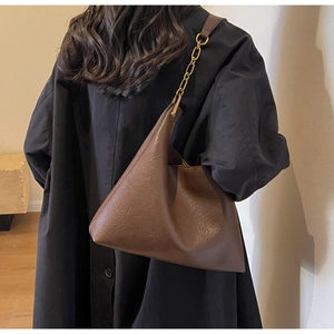Vue détaillée du sac cabas marron foncé avec structure triangulaire et chaîne